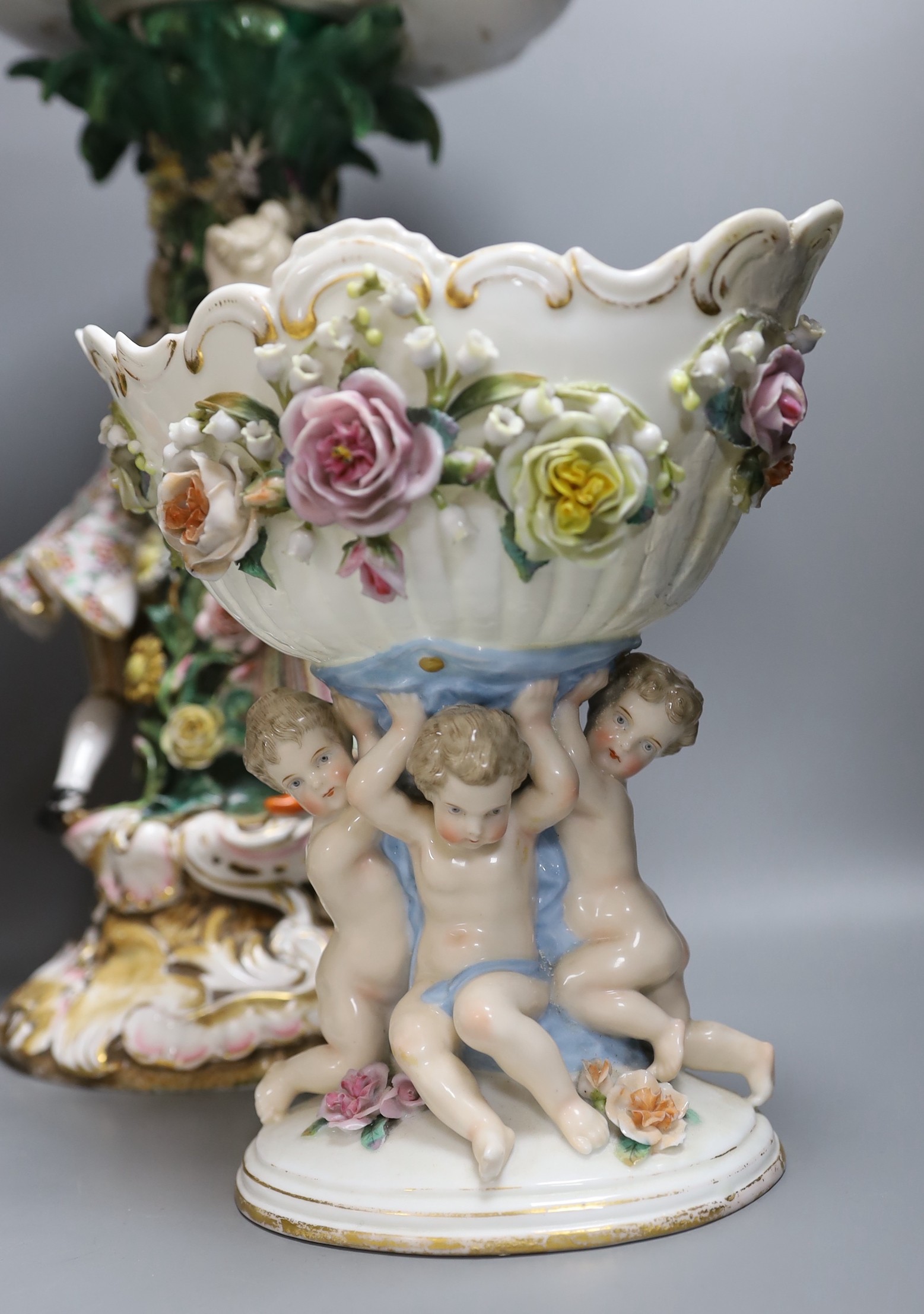 A 19th century Dresden floral encrusted centrepiece and two other continental porcelain centrepieces, tallest 46cm